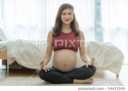 Asian Pregnant woman practice yoga in bedroom Asian Pregnant woman practice yoga in bedroom 54433349