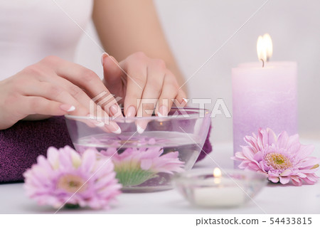 Closeup shot of a woman in a nail salon receiving a manicure by a beautician with cotton wool with 54433815