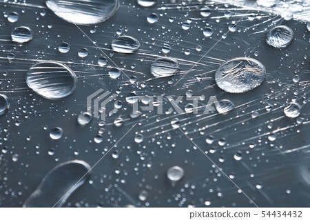 Close-up of raindrops of different sizes on the surface covered with cling film. Moisture weather 54434432