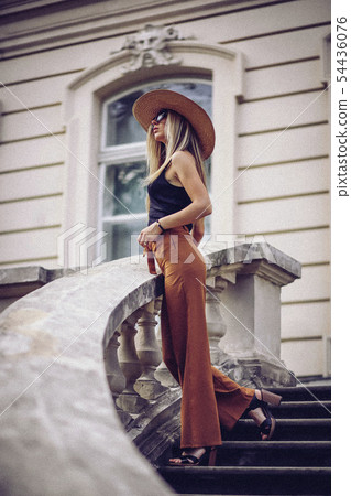 Noise. Vintage Style. Stylish woman in white hat standing on old town 54436076