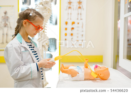Little girl in uniform playing doctor with doll 54436620