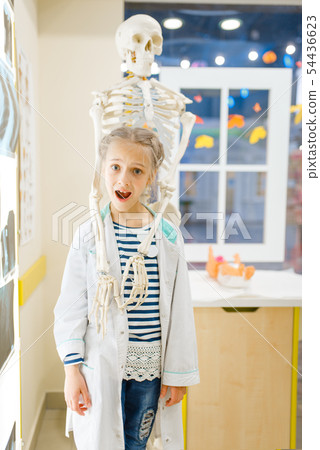 Girl in uniform near a skeleton, playing doctor 54436623