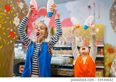 Girls in uniform playing with shampoo, playroom 54436682