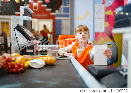 Cute girl at the register makes check for purchase 54436692