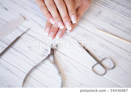 Manicure. Close up female hands situating on desk near nail tools 54436967
