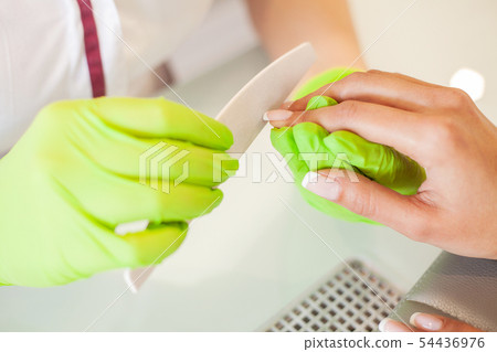 Manicure. Skillful master of manicure holding file in her hands while working in her beauty salon 54436976