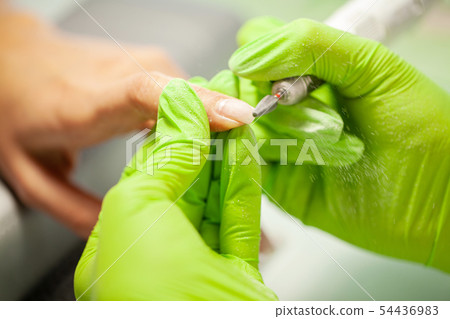 Manicure. Skillful master of manicure holding file in her hands while working in her beauty salon Manicure. Skillful master of manicure holding file in her hands while working in her beauty salon 54436983