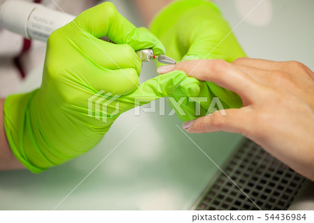 Manicure. Skillful master of manicure holding file in her hands while working in her beauty salon Manicure. Skillful master of manicure holding file in her hands while working in her beauty salon 54436984