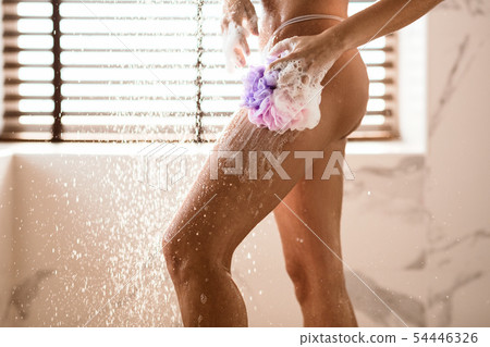 Woman Washing Her Legs With Sponge In Shower 54446326