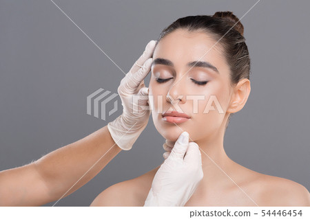 Young woman on consultation at beautician, grey background 54446454