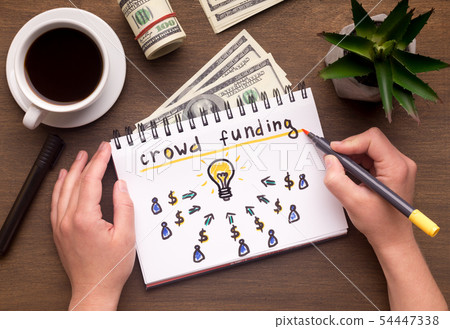 Woman hand writing in notebook crowdfunding sign on table Woman hand writing in notebook crowdfunding sign on table 54447338