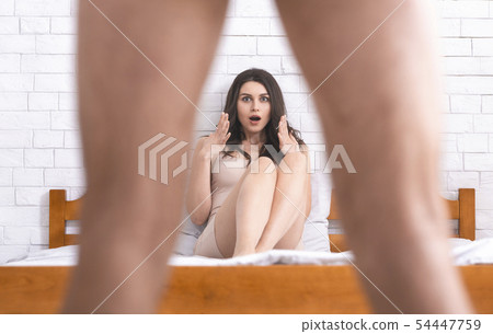 Woman in disbelief looking what's between man's legs 54447759