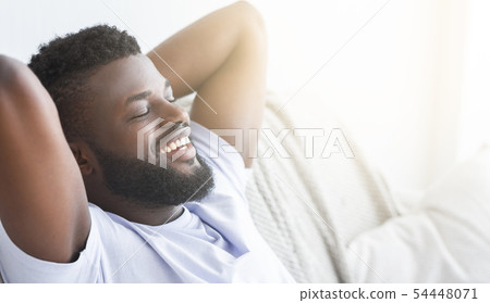 Satisfied black guy relaxing at home, lying with closed eyes 54448071