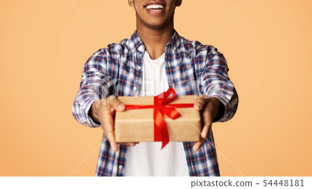 Cheerful Guy Offering Exclusive Gift Box to Camera 54448181