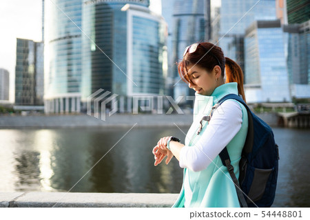 Portrait of young woman walking on the street, wearing cute trendy jacket. 54448801