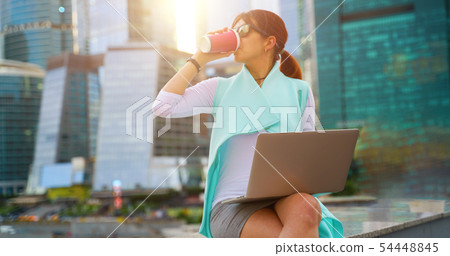 Portrait of business woman sitting with laptop and cup of coffee 54448845