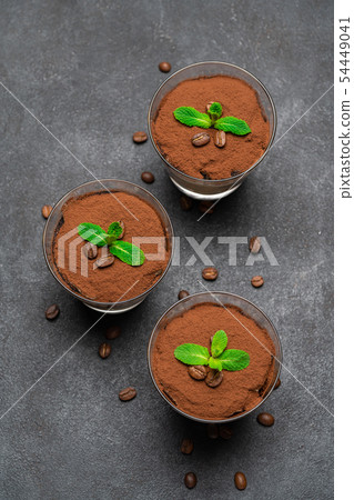 Classic tiramisu dessert in a glass on dark concrete background 54449041