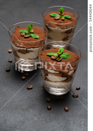 Classic tiramisu dessert in a glass on dark concrete background 54449044