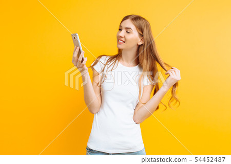 Beautiful young woman , uses a mobile phone, for 54452487