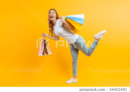 portrait of an enthusiastic young girl with bags 54452491