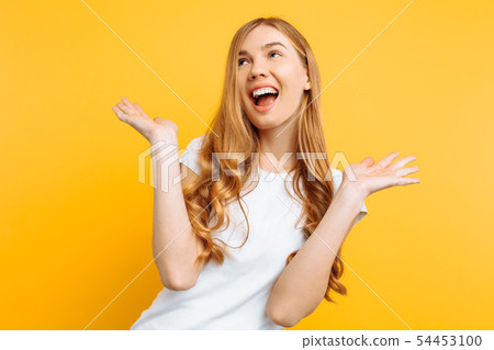 Happy young woman posing on yellow background 54453100