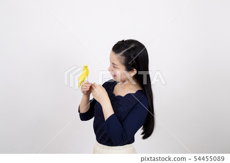 Smiling young woman playing with a swaddling in front of a white background 54455089