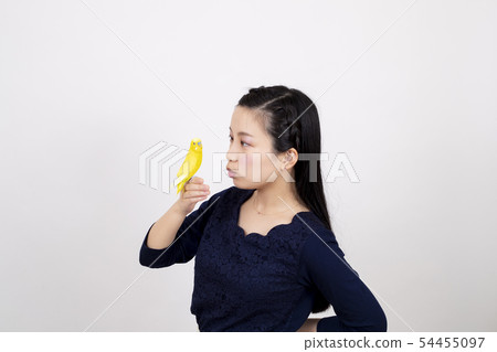 Smiling young woman playing with a swaddling in front of a white background Smiling young woman playing with a swaddling in front of a white background 54455097