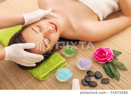 Close-up of a young woman getting spa treatment at beauty salon. spa face massage. facial beauty 54455666
