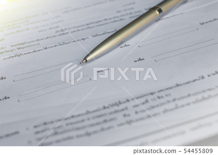 Low angle view of golden pen lying on white sheet 54455809
