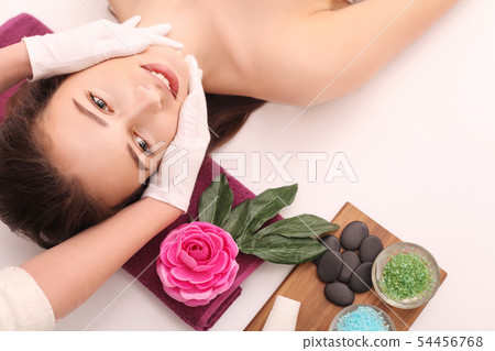 Woman under professional facial massage in beauty spa Woman under professional facial massage in beauty spa 54456768
