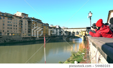 Unknown tourists make photos of famous Ponte Vecchio bridge in Florence, a major Italian landmark 54460103