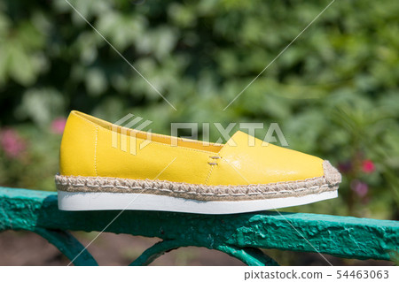Yellow espadrilles on a background of green grass. 54463063