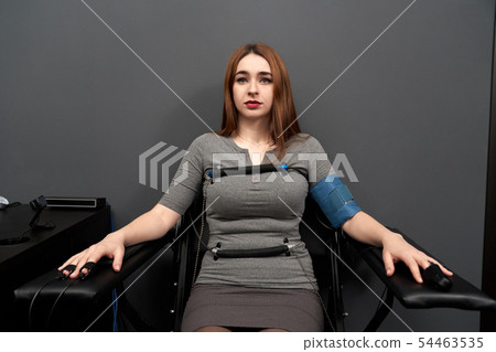 Woman sitting on chair during lie detector test 54463535