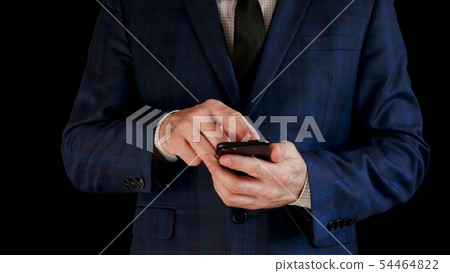 Close-up. A male businessman in a beautiful suit is working using a smartphone, touching the touch Close-up. A male businessman in a beautiful suit is working using a smartphone, touching the touch 54464822