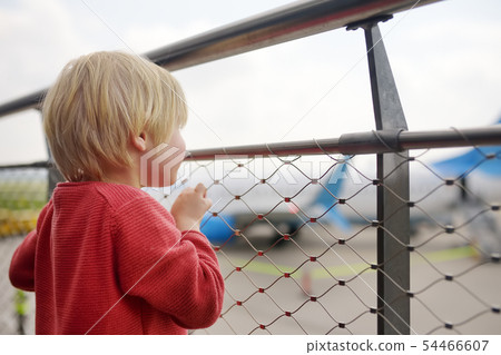 Cute little boy look at airplanes on observation Cute little boy look at airplanes on observation 54466607