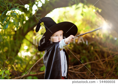 Little boy in pointed hat and black cloak playing Little boy in pointed hat and black cloak playing 54466608