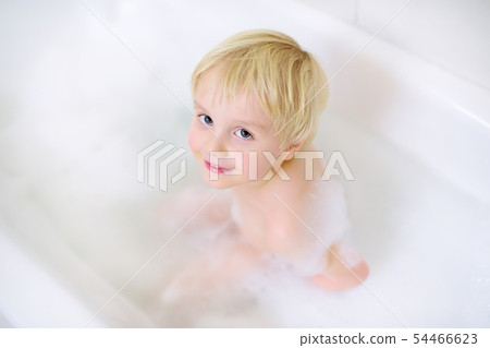 Cute little boy taking a foam bubble bath view 54466623