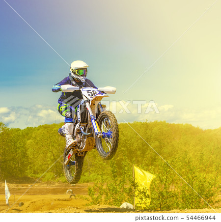 The motocross riders practice tricks on their The motocross riders practice tricks on their 54466944