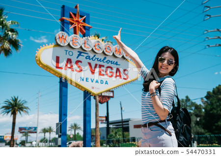 Happy young girl backpacker showing peace gesture 54470331