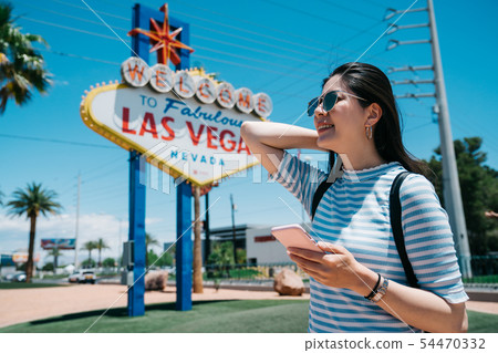 happy tourist using mobile phone in sun flare. happy tourist using mobile phone in sun flare. 54470332