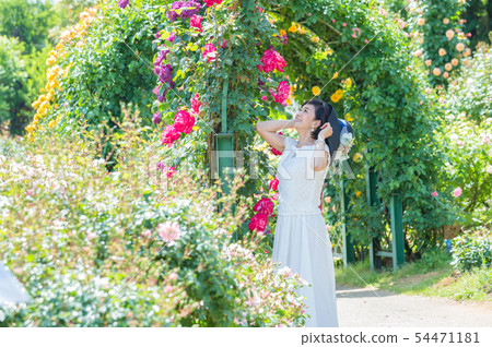  Middle woman enjoying the rose garden in full bloom Rose Arch Rose Garden 54471181