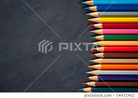 Colored pencils on chalkboard background. Colored pencils on chalkboard background. 54472402