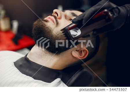 Stylish man sitting in a barbershop Stylish man sitting in a barbershop 54473307