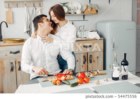 Beautiful couple prepare food in a kitchen Beautiful couple prepare food in a kitchen 54475556