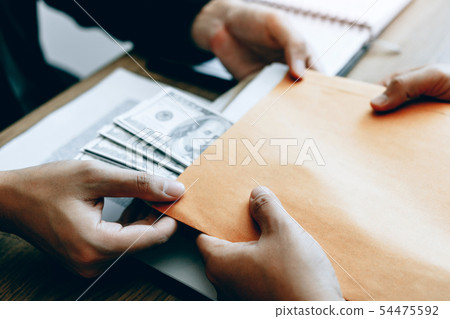 Businessman secretly giving a bribe by giving 54475592