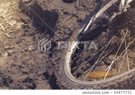 the Bicycle wheel is stuck in the mud. Close up the Bicycle wheel is stuck in the mud. Close up 54477731