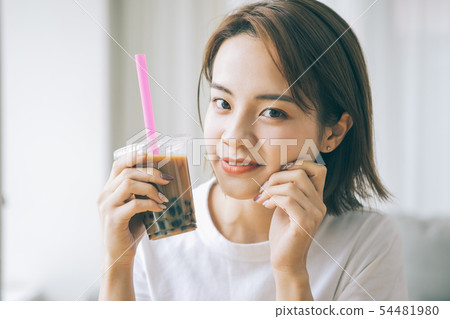 Young woman drinking tapioca milk tea 54481980
