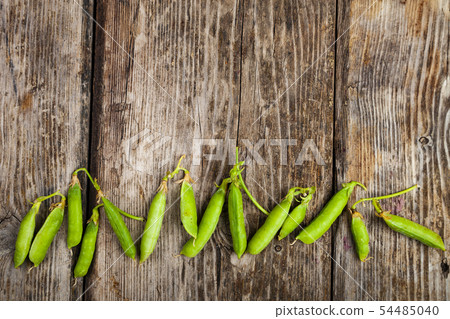 Pea pods on a wooden background. Pea pods on a wooden background. 54485040