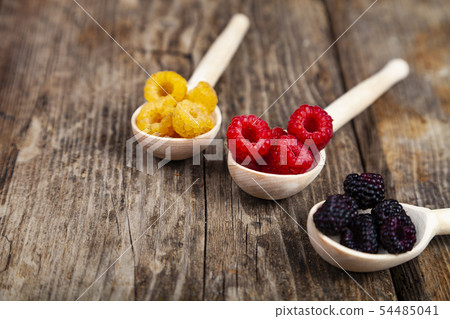 Ripe raspberry on an old wooden table. Ripe raspberry on an old wooden table. 54485041