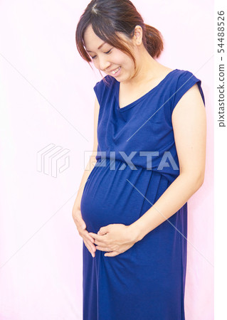 Laughing pregnant woman looking at her stomach Laughing pregnant woman looking at her stomach 54488526